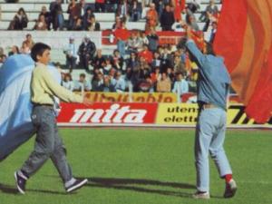 L'allora consueto scambio dei bandieroni che celebrava il gemellaggio tra ultrà del Napoli e della Roma